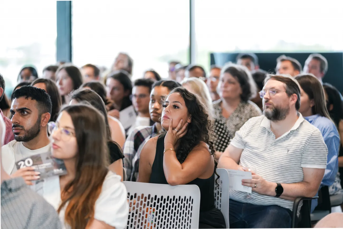 A number of people sitting in chairs watching a presentation