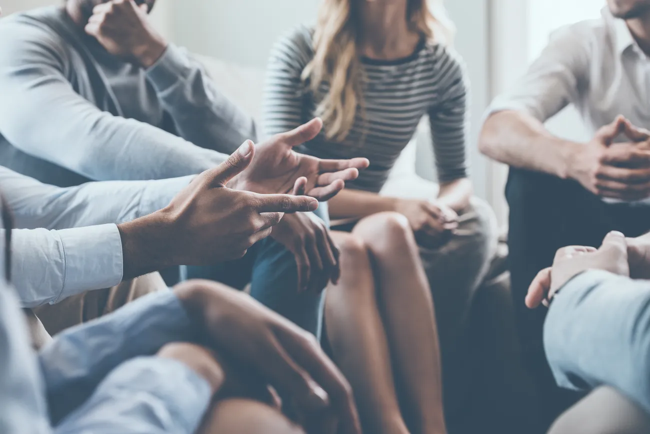 A number of people sitting in a circle in discussion