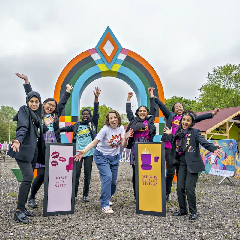 Women standing in front of a colourful banner